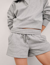Gray sweatshirt and shorts set on a plain background.